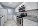 Efficient kitchen with white cabinets, granite countertops, stainless steel appliances, and access to the backyard at 8520 Mission Hills Rd, Charlotte, NC 28227