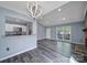Open concept living room featuring new gray flooring, updated lighting, and an adjacent kitchen with granite countertops at 8520 Mission Hills Rd, Charlotte, NC 28227