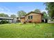 Spacious backyard with green grass, brick home, and a swing set for Gathering fun at 924 Carrington Dr, Charlotte, NC 28214