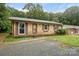 Charming brick single-story home with brown shutters and trim, complemented by a neatly maintained gravel driveway at 924 Carrington Dr, Charlotte, NC 28214