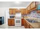 Functional kitchen featuring wooden cabinets, white appliances, and a tiled backsplash for a clean, updated look at 924 Carrington Dr, Charlotte, NC 28214