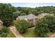 Aerial view of landscaped home, driveway, backyard with patio and mature trees at 9717 Waterton Ct, Huntersville, NC 28078