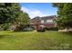 Large backyard with grass, mature trees, brick house, stone patio and patio furniture at 9717 Waterton Ct, Huntersville, NC 28078