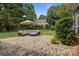 Backyard stone patio with plush furniture, umbrella, manicured grass, and greenery at 9717 Waterton Ct, Huntersville, NC 28078
