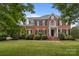 Charming brick home with lush green lawn, mature trees, and classic architectural details at 9717 Waterton Ct, Huntersville, NC 28078