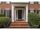 Inviting entryway with brick steps, elegant columns, and a stylish black door with a wreath at 9717 Waterton Ct, Huntersville, NC 28078
