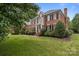 Stately brick home featuring a well-manicured lawn, lush landscaping, and elegant architectural details at 9717 Waterton Ct, Huntersville, NC 28078