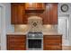 Close up of the range and backsplash in the kitchen featuring custom wood cabinets and granite counters at 9717 Waterton Ct, Huntersville, NC 28078