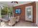 Covered porch with brick wall, tile floors, wicker furniture, and blue artwork at 9717 Waterton Ct, Huntersville, NC 28078