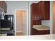 Efficient kitchen with warm wood cabinets and a view to a closet with an open door at 9823 Hyde Glen Ct, Charlotte, NC 28262