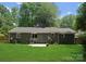 Back exterior view of home with green lawn, patio and fire pit at 1027 Dresden W Dr, Charlotte, NC 28205