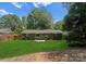 Back exterior view of the home featuring a green lawn and patio at 1027 Dresden W Dr, Charlotte, NC 28205