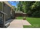 A backyard with a concrete patio and lush green lawn and fire pit at 1027 Dresden W Dr, Charlotte, NC 28205