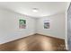 Bedroom featuring hardwood floors, two windows, and closet at 1027 Dresden W Dr, Charlotte, NC 28205