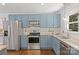Well-lit kitchen featuring blue cabinets, granite countertops, stainless steel appliances, and ample cabinet space at 1027 Dresden W Dr, Charlotte, NC 28205