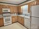 Classic kitchen with wooden cabinets and white appliances at 10414 Tillman Steen Rd, Indian Land, SC 29720
