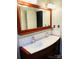 Bathroom vanity featuring a large mirror, double sinks, modern faucets, and decorative wood trim at 106 Condover Pl, Charlotte, NC 28270