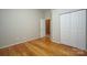 Bedroom featuring hardwood flooring, a neutral wall color, and a closet with folding doors at 11021 Travis Gulch Dr, Charlotte, NC 28277