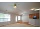 Open living space features a ceiling fan, kitchen cabinets, and access to the outdoors via a sliding glass door at 11021 Travis Gulch Dr, Charlotte, NC 28277