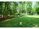 Expansive backyard with mature trees and a shed, creating a private outdoor space for relaxing and recreation at 116 April Ln, Dallas, NC 28034