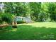 Large grassy backyard with mature trees and a shed that has a deck, offering a private outdoor space at 116 April Ln, Dallas, NC 28034