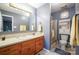 Well-lit bathroom with a large mirror, vanity with storage, and a glass-enclosed shower at 116 April Ln, Dallas, NC 28034