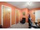 Inviting secondary bedroom painted a warm orange, complete with gaming chair and neutral carpeting at 116 April Ln, Dallas, NC 28034