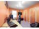 Orange-walled office space with a desk, windows, carpet, and a sleek black and white gaming chair at 116 April Ln, Dallas, NC 28034