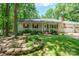 Charming home features a landscaped front yard with stone accents and a welcoming porch at 116 April Ln, Dallas, NC 28034