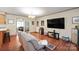 Comfortable living room with a large screen TV, hardwood floors, and access to the dining room at 116 April Ln, Dallas, NC 28034