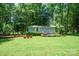 Outdoor shed with a small deck area surrounded by a lush green lawn and trees at 116 April Ln, Dallas, NC 28034
