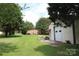 Spacious backyard featuring lush green grass, a brick house with a back porch, and a detached garage at 116 Woodbark Ln, Kings Mountain, NC 28086
