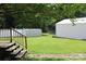Large backyard featuring a storage shed and a white metal outbuilding, and a wooden deck with stairs at 116 Woodbark Ln, Kings Mountain, NC 28086