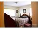 Traditional bedroom with a wooden bed frame, soft bedding, and natural light from the window at 116 Woodbark Ln, Kings Mountain, NC 28086