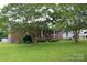 Charming brick home with a covered front porch, mature trees, and well-manicured lawn at 116 Woodbark Ln, Kings Mountain, NC 28086