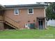 Back exterior of the home with brick facade, backyard access, and an outdoor staircase at 116 Woodbark Ln, Kings Mountain, NC 28086