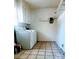 Functional laundry room with washer, dryer, white cabinets and tile floors at 116 Woodbark Ln, Kings Mountain, NC 28086