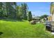 Expansive backyard features lush green grass, mature trees, and a patio area perfect for outdoor entertaining at 11618 Macallano Dr, Charlotte, NC 28215