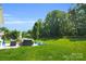 Picturesque backyard featuring a well-manicured lawn, patio seating, and lush trees for ultimate relaxation at 11618 Macallano Dr, Charlotte, NC 28215