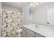 Clean bathroom featuring a single sink vanity and a shower with colorful fish-themed curtain at 11618 Macallano Dr, Charlotte, NC 28215