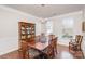 Formal dining room with wooden table, chairs, hardwood floors, and decorative china cabinet at 11618 Macallano Dr, Charlotte, NC 28215
