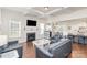 Open concept living room and kitchen featuring a fireplace, large windows, hardwood floors and comfortable seating at 11618 Macallano Dr, Charlotte, NC 28215