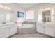 Bright bathroom showcasing a large soaking tub, double sinks, and modern fixtures at 11618 Macallano Dr, Charlotte, NC 28215