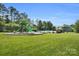 Community playground with slides, climbing structures, and lush green lawn next to community pool at 11618 Macallano Dr, Charlotte, NC 28215