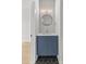 Stylish powder room with blue vanity, round mirror, modern lighting, and geometric tile floor at 1356 Briar Creek Rd, Charlotte, NC 28205