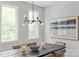 Bright dining area with natural light, showcasing modern lighting, a decorative painting, and elegant table setting at 1356 Briar Creek Rd, Charlotte, NC 28205
