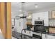 Beautiful kitchen showcasing modern lighting, black countertops, white cabinetry, and open shelving at 1356 Briar Creek Rd, Charlotte, NC 28205