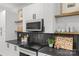 Stylish kitchen with black countertops, white cabinets, stainless steel microwave, and decorative backsplash tiles at 1356 Briar Creek Rd, Charlotte, NC 28205