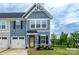 Charming townhome featuring a well-manicured lawn, attached garage, and inviting blue siding at 154 Stella Ln # A, Troutman, NC 28166