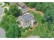 Aerial view of the home showcasing the sport court, lush lawn, mature trees, and manicured landscaping at 1728 Shadow Forest Dr, Matthews, NC 28105